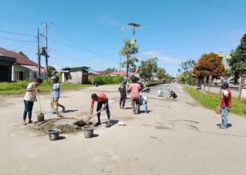 Warga dan Tukang Ojek di Namrole Patungan Tambal Jalan Berlubang