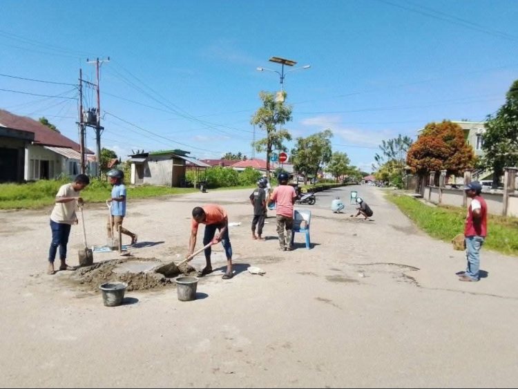 Warga dan Tukang Ojek di Namrole Patungan Tambal Jalan Berlubang